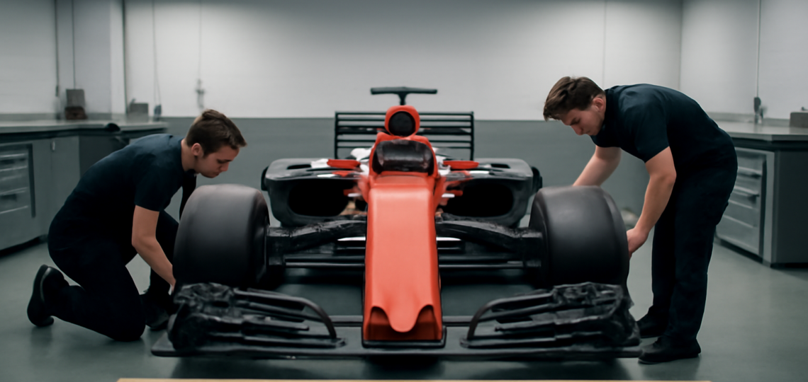 Mobil Formula 1 di garasi saat insinyur memeriksa komponen aerodinamika